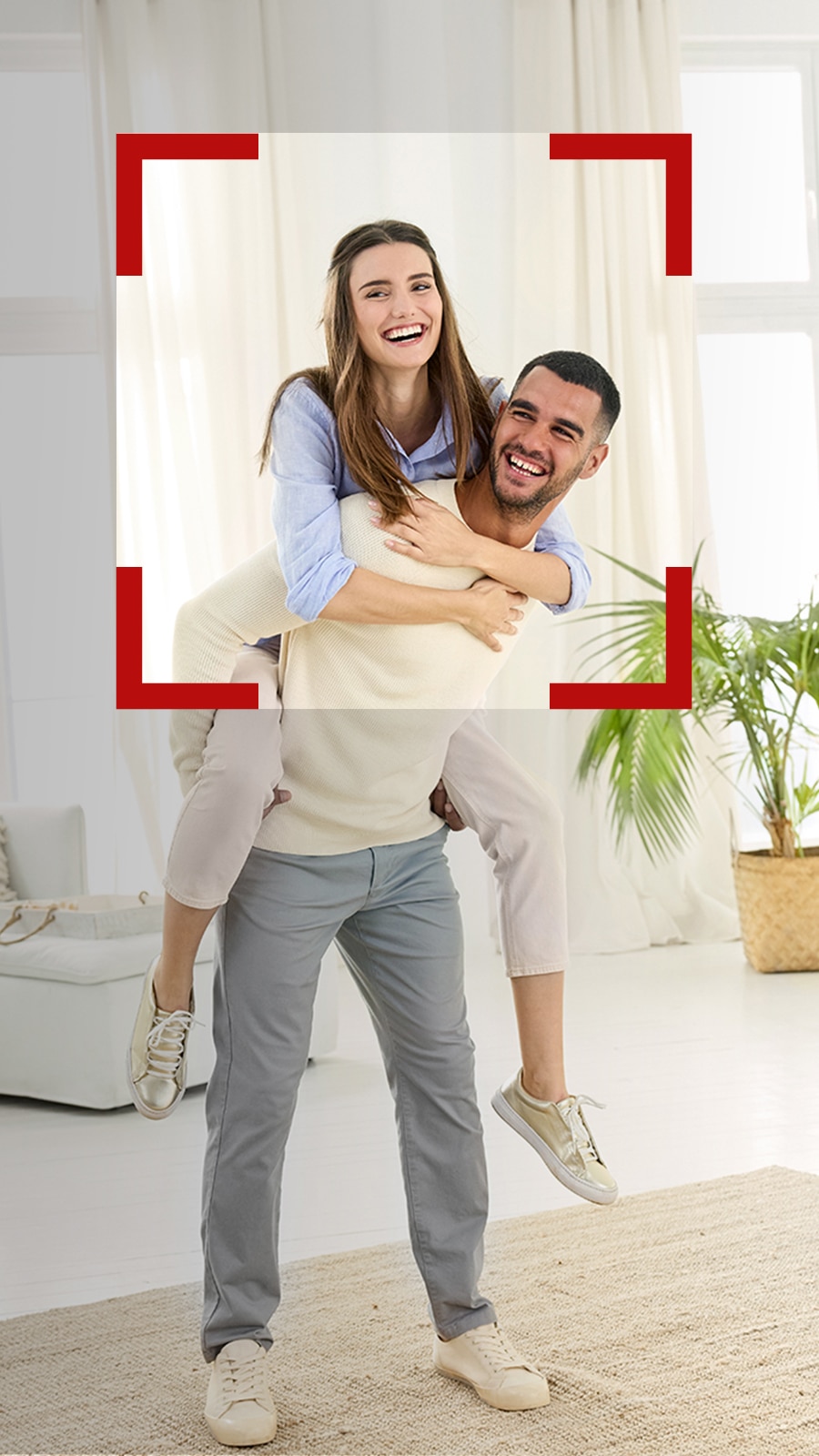 زوج شاب يحمل زوجته على ظهره ويلهوان.