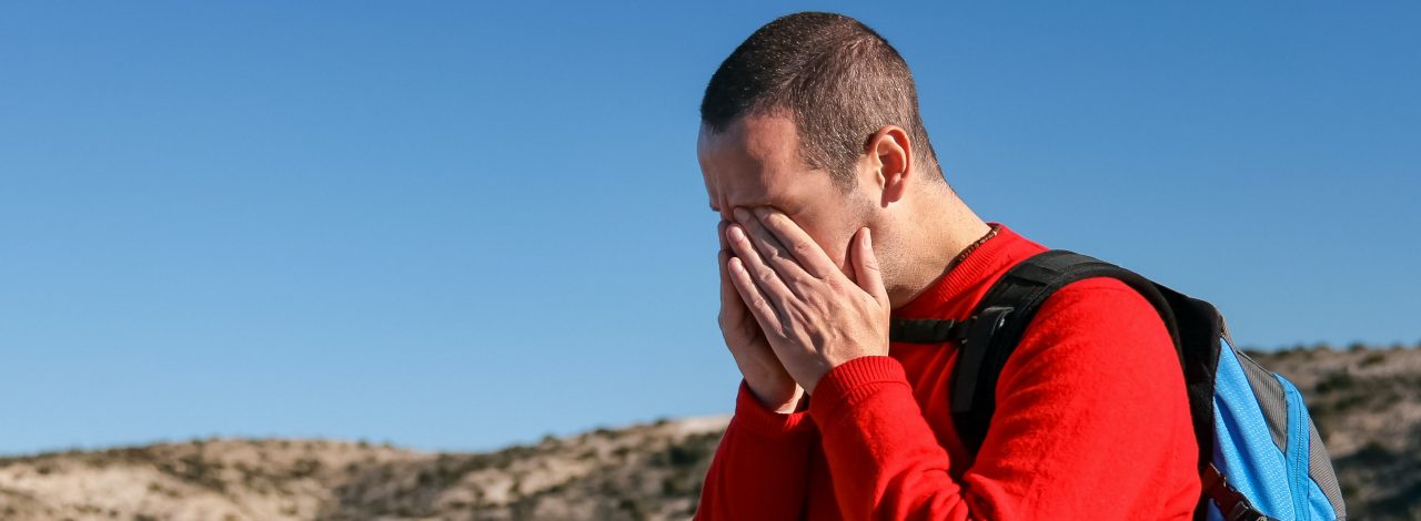 Eine Person schlägt die Hände vorm Gesicht zusammen und scheint verzweifelt.