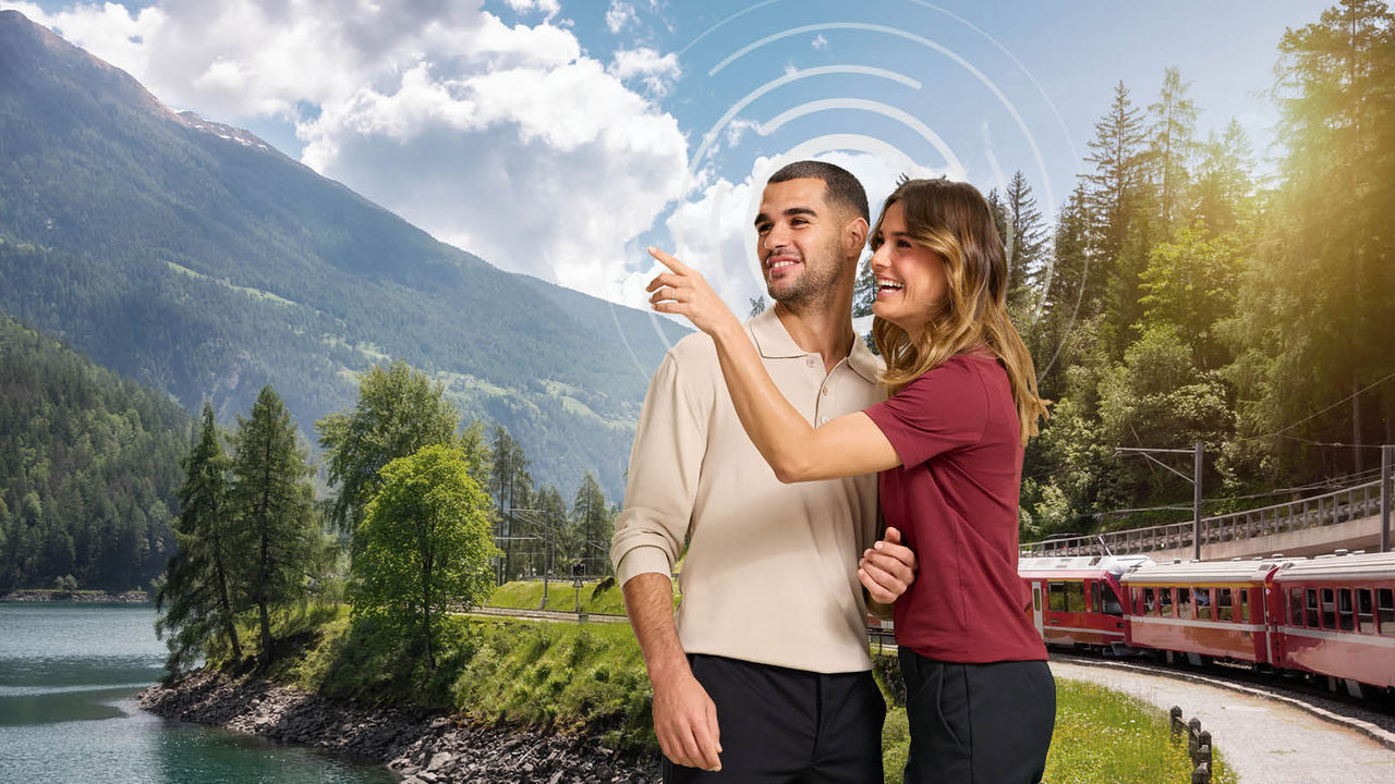 Couple in nice green landscape, train passing behind them