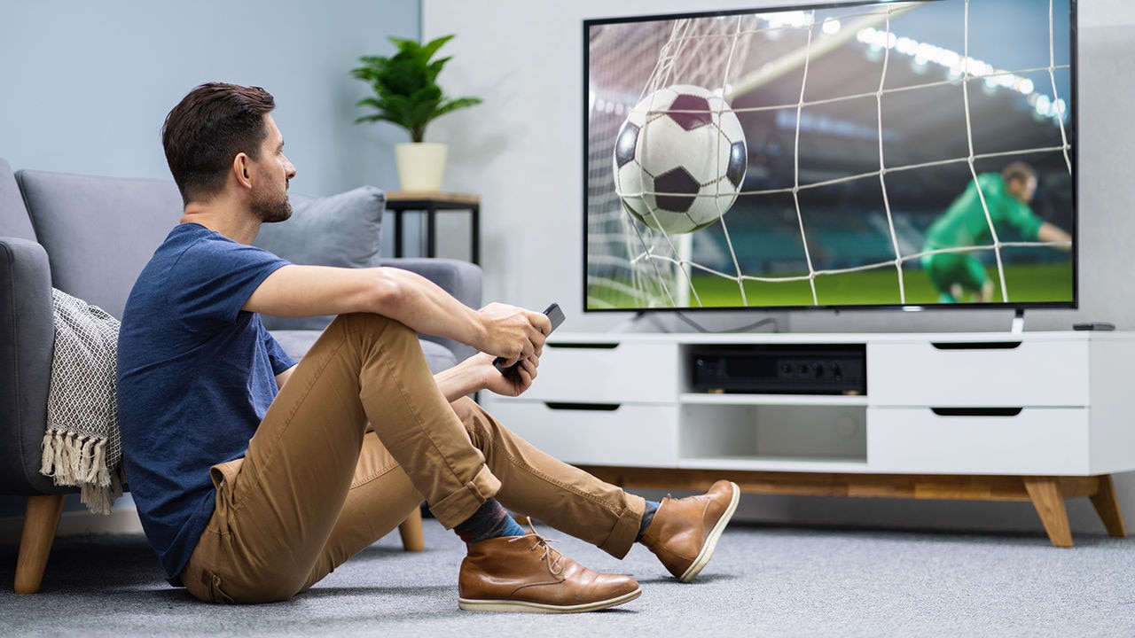 Hombre viendo el fútbol en la TV