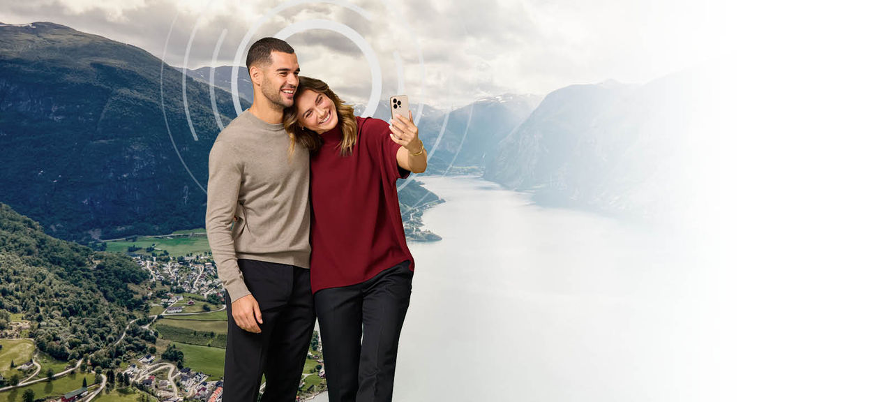 زوجی در مقابل منظره‌ای پانوراما در حال گرفتن سلفی