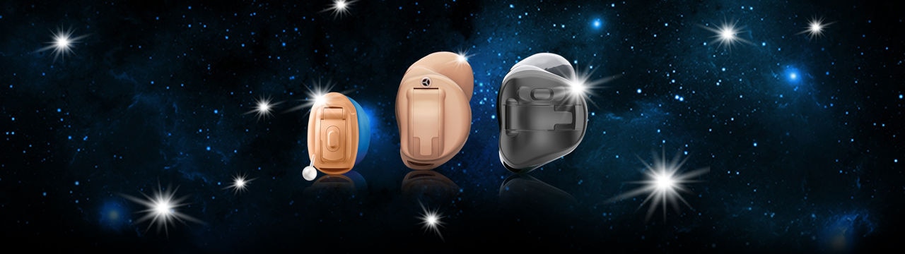 STRATOS in-the-ear hearing aids displayed against a dark galaxy background.