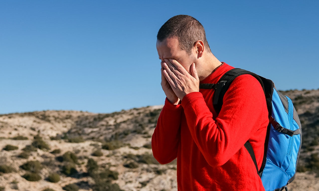 Une personne portant les mains à son visage, l’air accablé. 